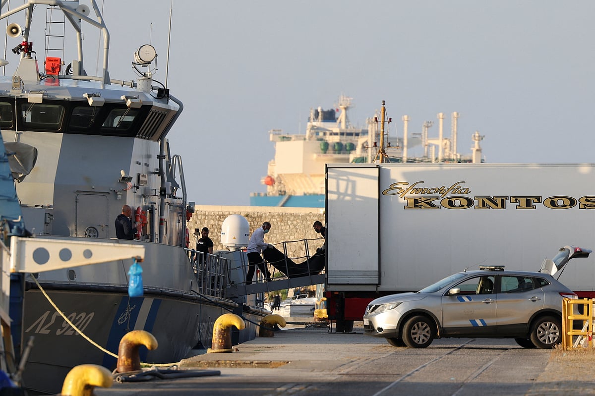 Men transfer body bags carrying migrants who died after their boat capsized in the open sea off Greece, onboard a Hellenic Coast Guard vessel at the port of Kalamata, Greece, June 15, 2023