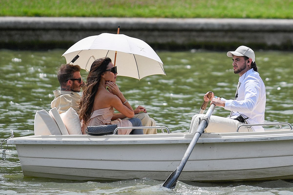 British former football player David Beckham (L) and British singer and fashion designer Victoria Beckham (C) arrive by row-boat at the Jacquemus Menswear Spring-Summer 2024 show as part of the Paris Fashion Week, at the Chateau de Versailles, in Versailles, southwest of Paris, on 26 June, 2023.