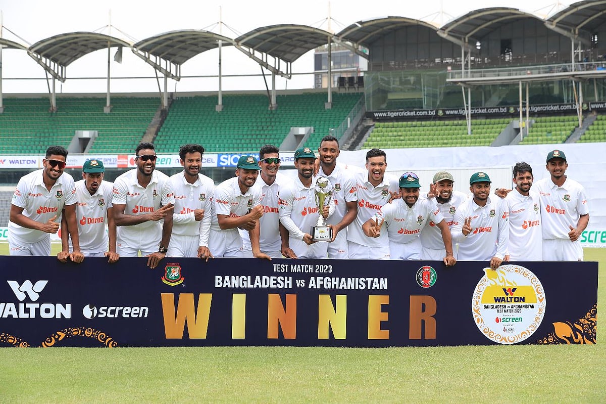Bangladesh cricketers celebrate with the trophy after winning the one-off Test against Afghanistan at the Sher-e-Bangla National Cricket Stadium in Dhaka on 17 June 2023.