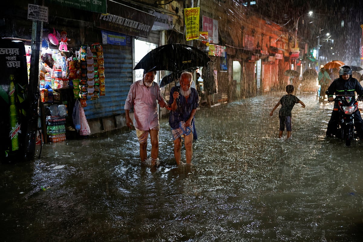People wade through a flooded street amid continuous rain before the Cyclone Sitrang hits the country in Dhaka, Bangladesh, October 24, 2022