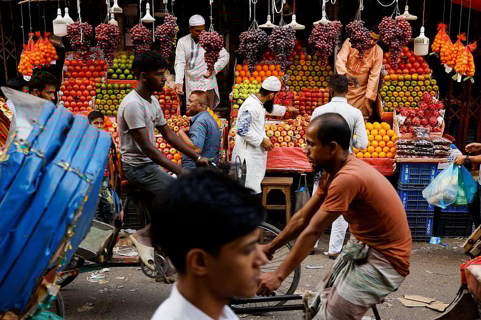 Commuters pass by a fruit shop in Dhaka, Bangladesh, on 11 November, 2022.