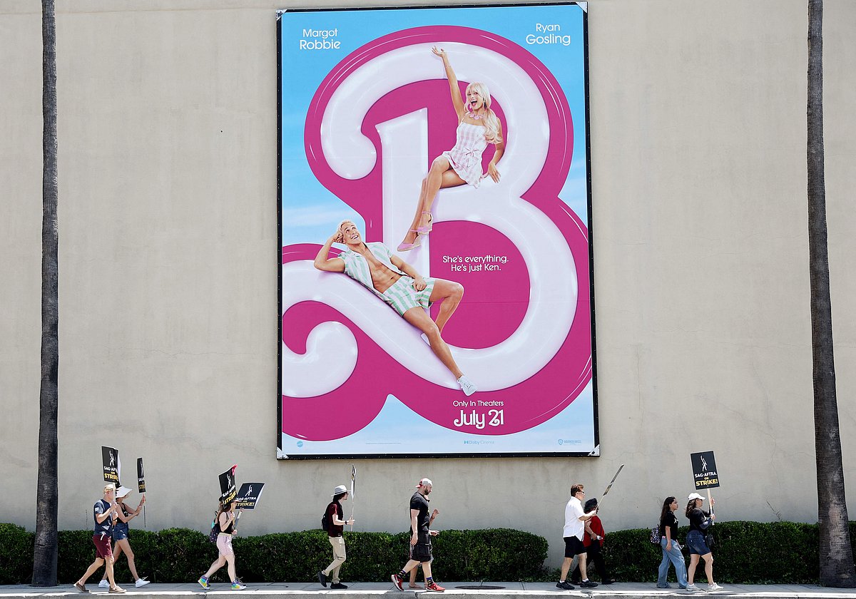 Striking SAG-AFTRA members picket with striking WGA (Writers Guild of America) workers near a billboard for the Barbie movie outside Warner Bros. Studio in Burbank, California, on 17 July, 2023.