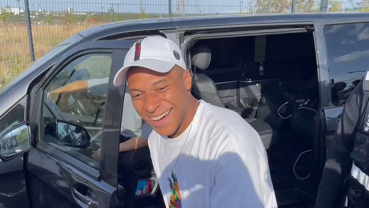A video image grab shows Paris Saint-Germain's forward Kylian Mbappe as he stops at the entrance of the Paris Saint-Germain training grounds to meet with fans and sign autographs, on the sidelines of a training session in Poissy, western suburbs of Paris on 22 July 2023