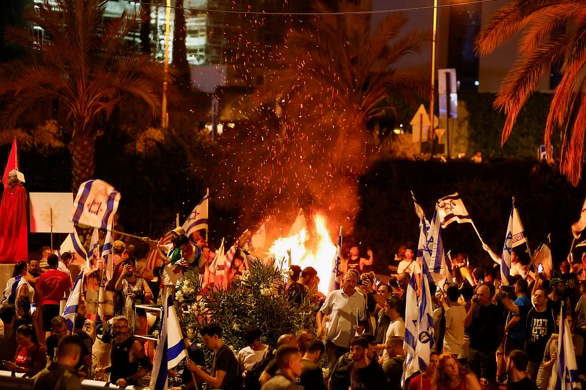 People demonstrate near a fire on the 'Day of National Resistance' in protest against Israeli Prime Minister Benjamin Netanyahu and his nationalist coalition government's judicial overhaul, in Tel Aviv, Israel July 18, 2023