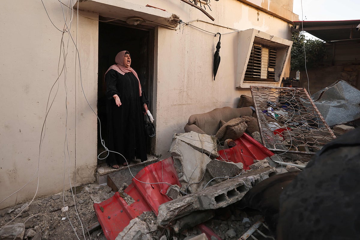 A neighbour reacts after Israeli soldiers demolished a house at the Asker camp for Palestinian refugees east of Nablus city in the occupied West Bank, early on 8 August, 2023