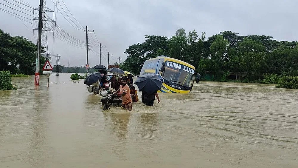 The passenger buses got marooned on the Chattogram-Cox's Bazar highway. People are braving the waist-deep water to reach their destination in Dakshin Hashimpur area of Chandanaish upazila in Chattogram on 8 August, 2023.