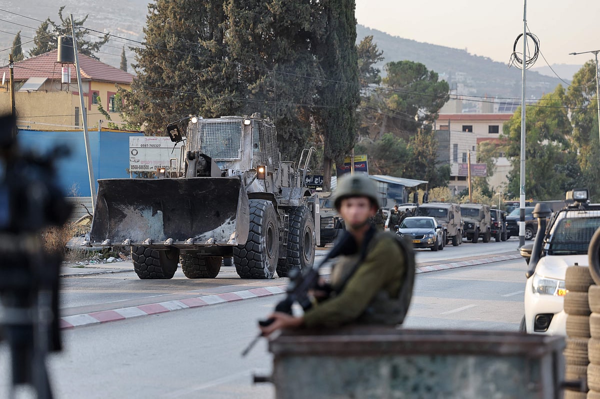 An Israeli security forces bulldozer arrives to a military roadblock following a reported attack in the town of Huwara in the occupied West Bank, on 19 August, 2023