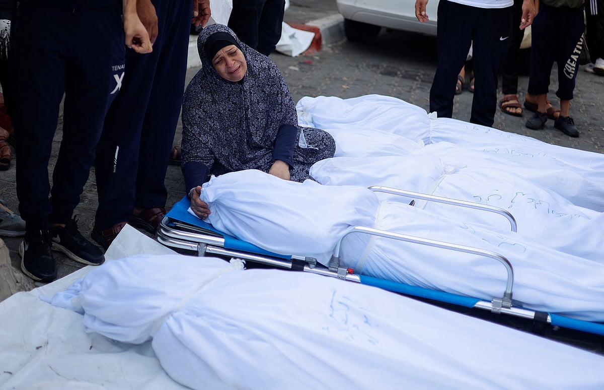 A relative reacts next to the bodies of Palestinians killed in Israeli strikes, at a hospital in Gaza City, October 11, 2023.