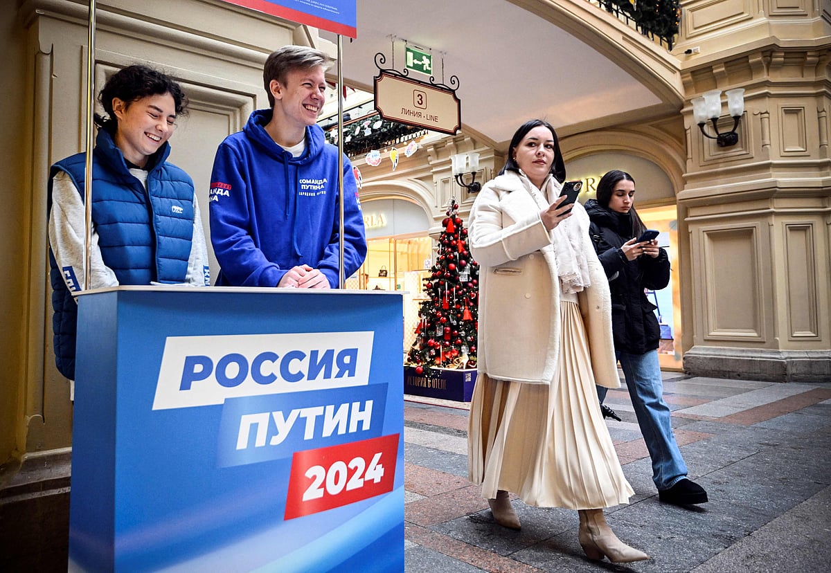 People walk past an election campaign stand of Russian President Vladimir Putin for collecting signatures to support him as a candidate for the upcoming presidential election, at the GUM department store in Moscow, on 19 January, 2024