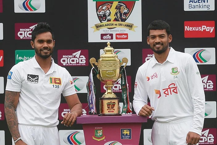 Sri Lanka skipper Dhananjaya de Silva and Bangladesh skipper Najmul Hossain posses with the trophy