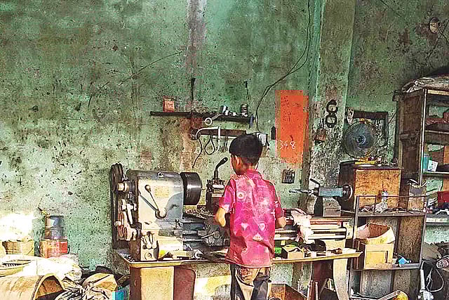 A 12-year-child is working hazardous work at a workshop in Keraniganj. He is cutting pipe with a heavy machine. The picture was taken on 24 April.