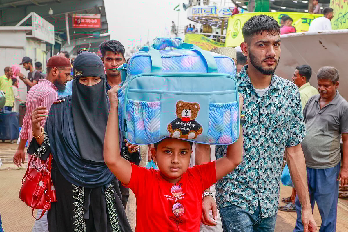 A boy carries a bag as his family is about to board a launch since they leave the capital to spend the Eid holidays at home. The picture was taken from the Sadarghat Launch Terminal, Dhaka on 14 June 2024.