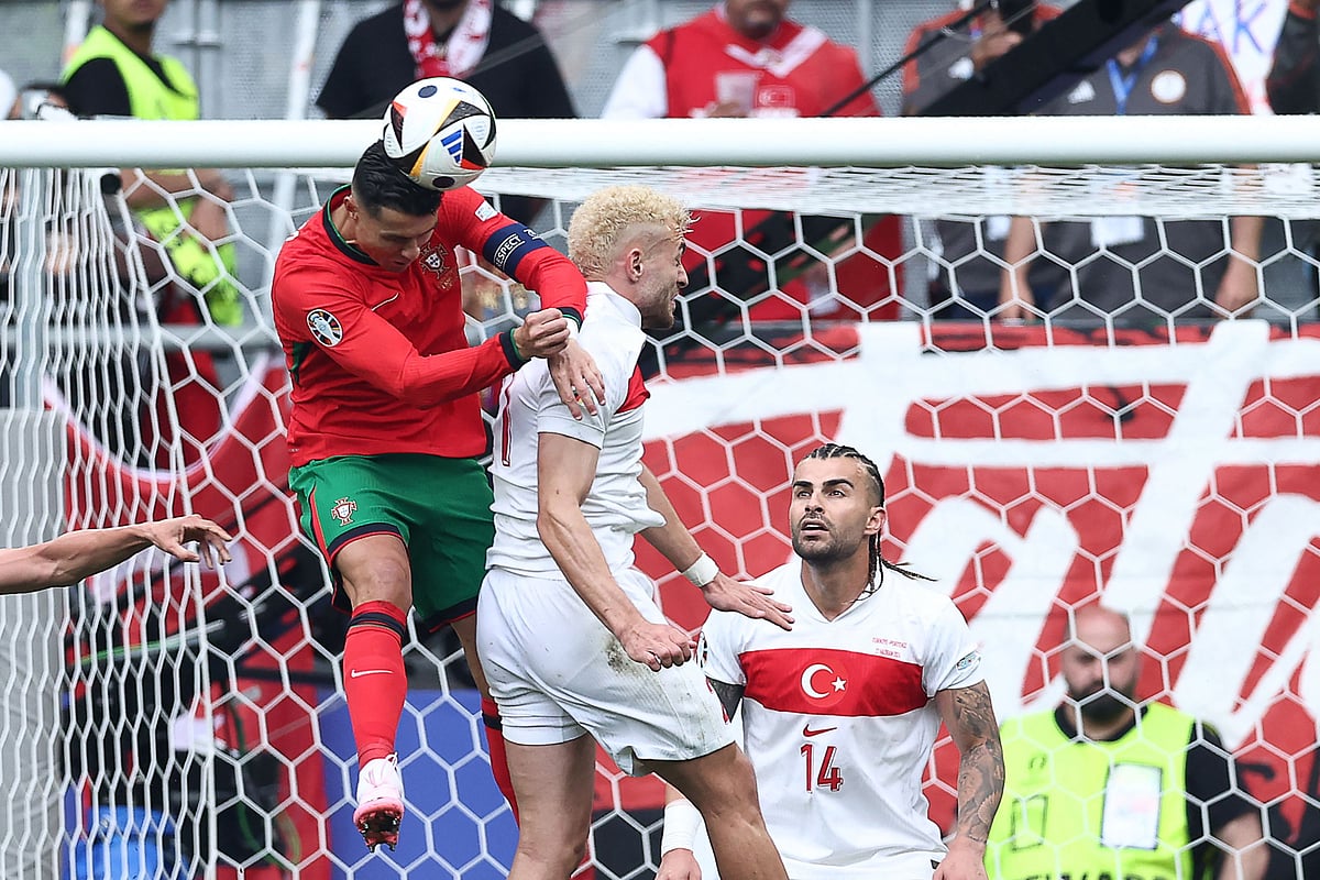 Portugal's forward #07 Cristiano Ronaldo heads the ball next to Turkey's forward #21 Baris Alper Yilmaz (C) and Turkey's defender #14 Abdulkerim Bardakci during the UEFA Euro 2024 Group F football match between Turkey and Portugal at the BVB Stadion in Dortmund on 22 June 2024.