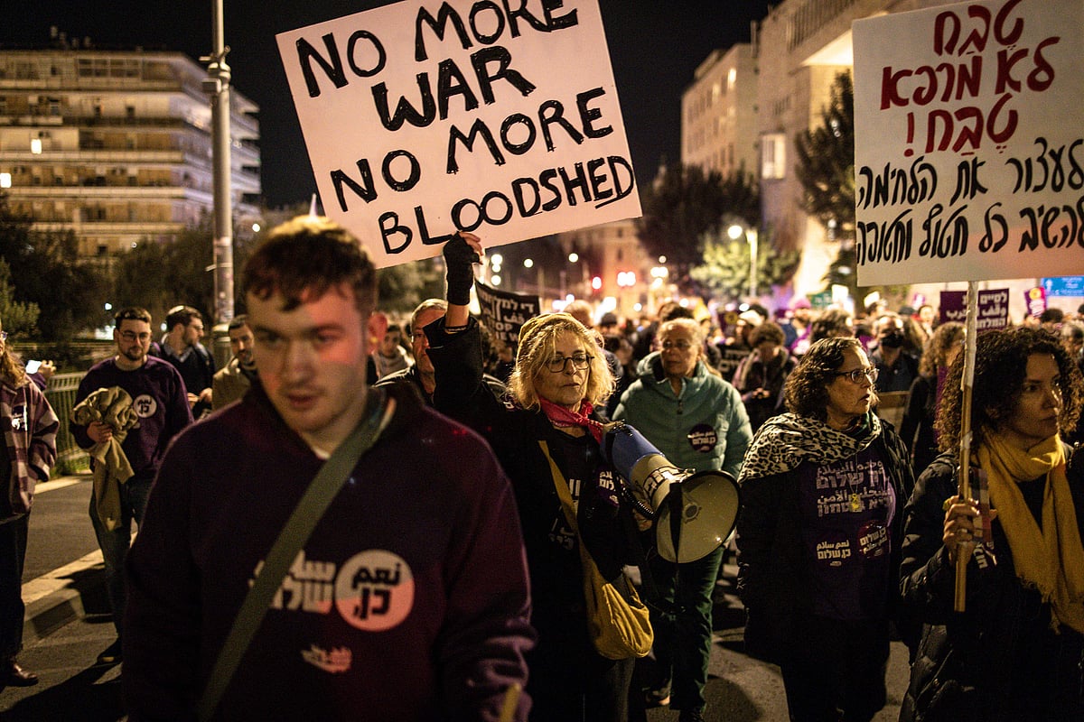 People raise placards during a pro-ceasefire agreement rally in Jerusalem on 16 January, 2025