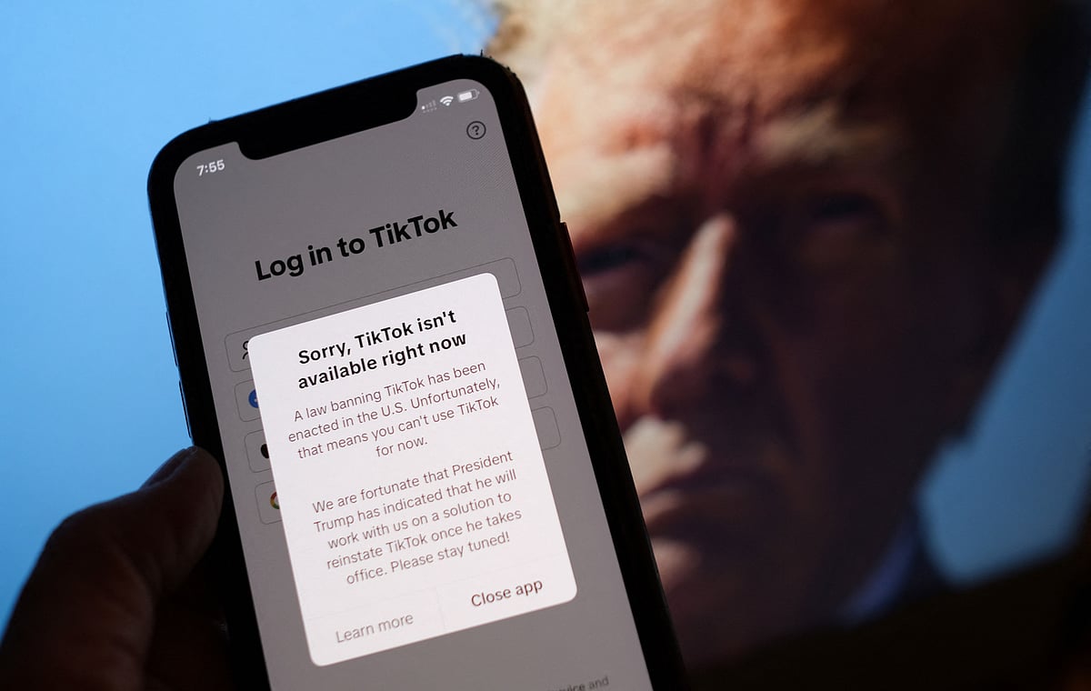 This illustration photo taken in Los Angeles on 18 January, 2025, shows the TikTok app on a smartphone screen in front of a photo of US President-elect Donald Trump.