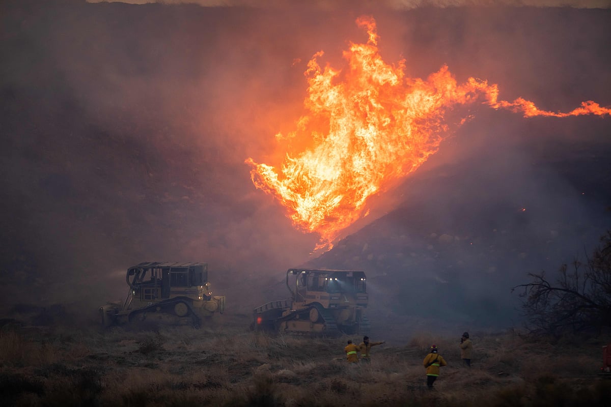 A bulldozer operator drives into the flames to set up a containment line for the Hughes Fire in Castaic, a neighborhood in northwest Los Angeles County, California, on 22 January, 2025