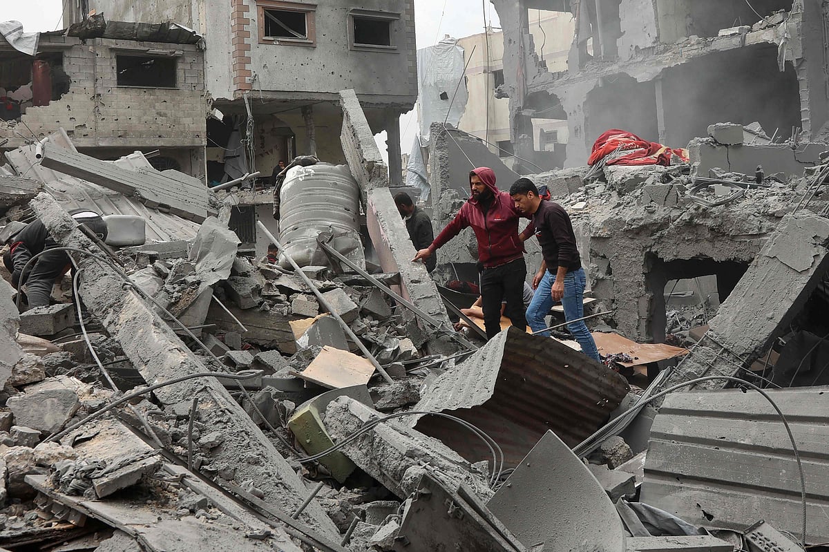 Palestinian men walk amidst the rubble of a building following an Israeli strike on a residential area in Gaza City's Shujaiyya neighbourhood, on 9 April, 2025.