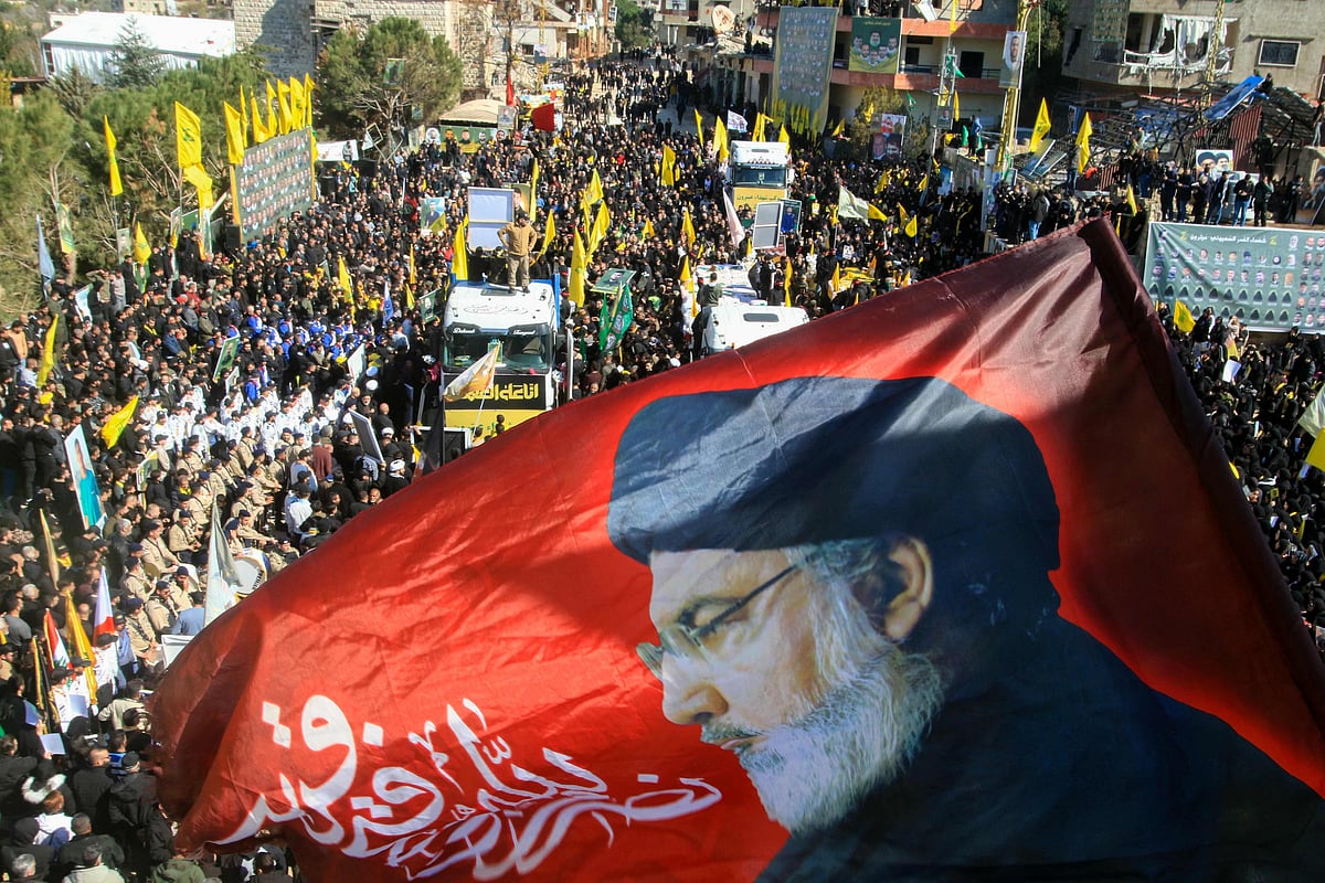 A flag bearing a portrait of slain Hezbollah leader Hassan Nasrallah waves during the funeral on February 28, 2025 of 95 Hezbollah fighters and civilians killed in Israeli airstrikes during hostilities that lasted more than a year between Israel and Hezbollah, in the southern Lebanese border town of Aitaroun