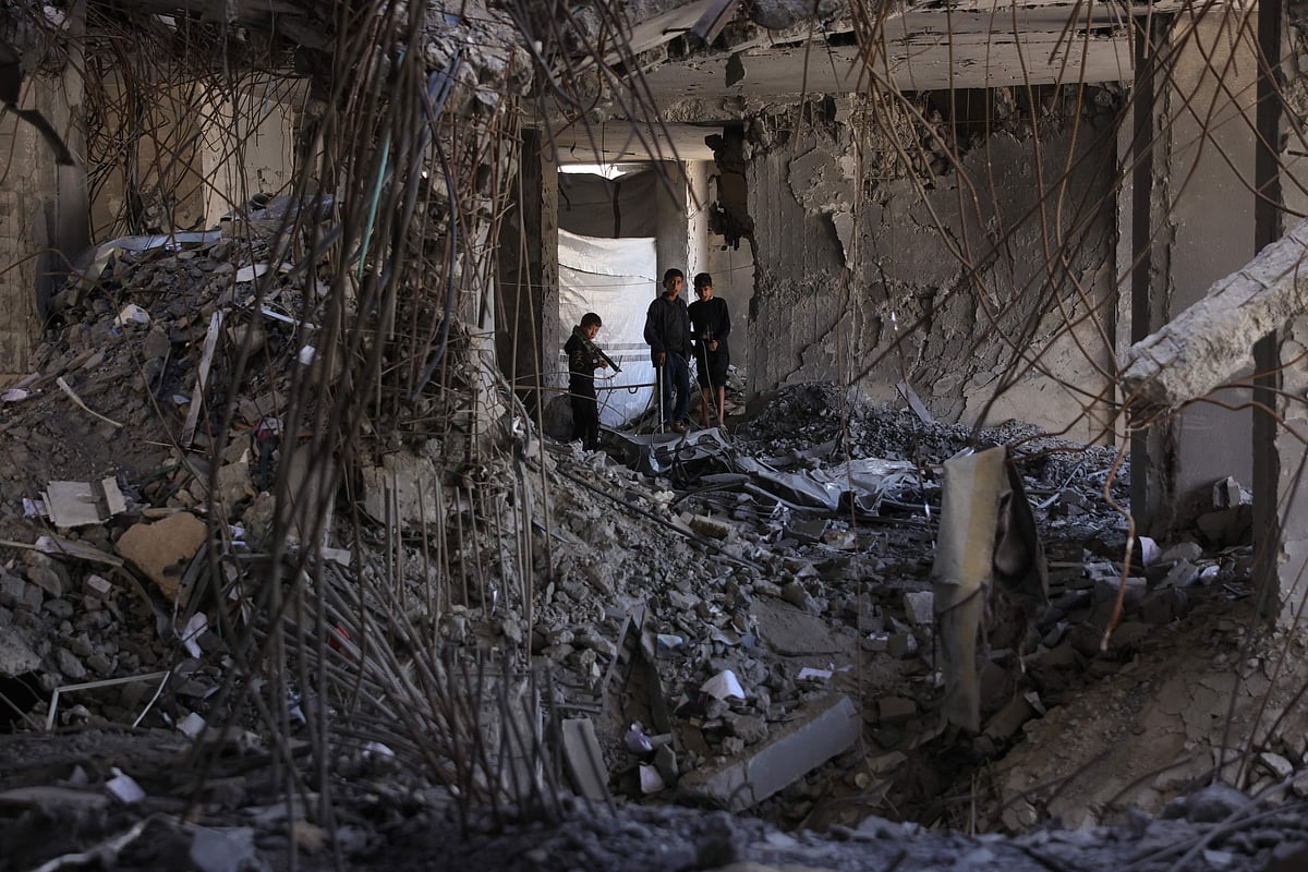 Displaced Palestinians walk about the debris inside a building, part of the heavily damaged Islamic University campus where they took refuge, in Gaza City on April 16, 2025.