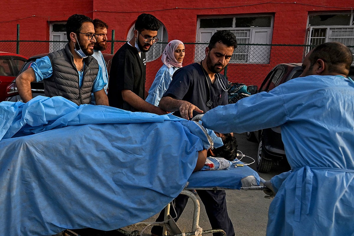 Paramedics carry an injured tourist at a hospital in Anantnag, south of Srinagar, on 22 April, 2025, following an attack
