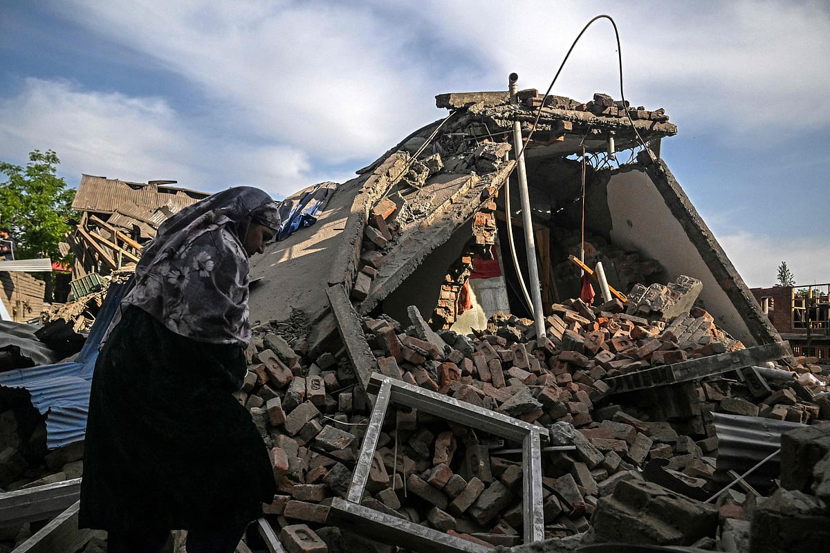 A woman walks through the debris of a demolished house related to the family of Ahsan Ul Haq Sheikh, who is suspected of involvement in the Pahalgam tourist attack, in Murran village of Pulwama, south of Srinagar, on 26 April 2025.