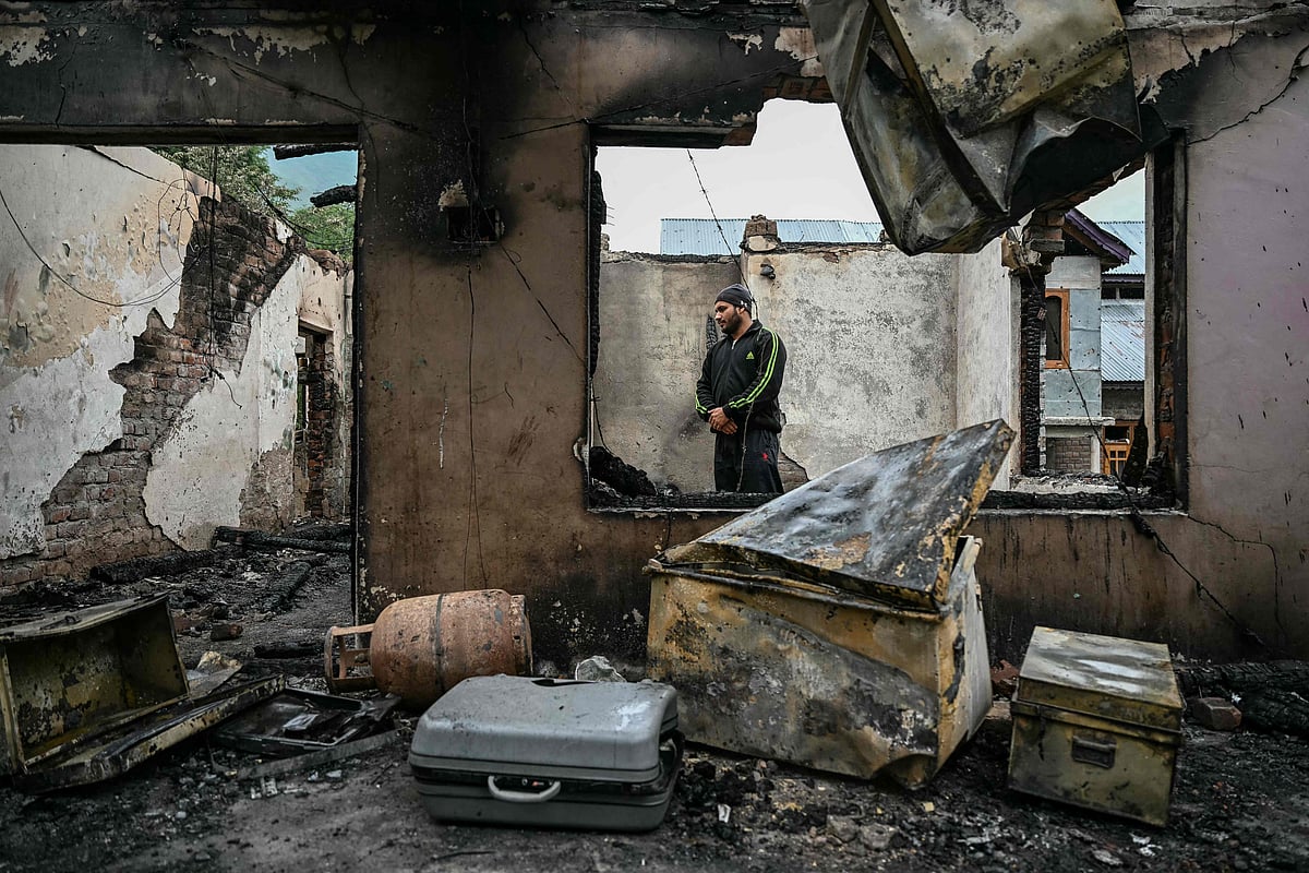 A man stands inside his house destroyed by Pakistani artillery shelling at the Salamabad village in Uri, about 110kms from Srinagar, on 8 May 2025. India's government said on 8 May that Pakistan launched an overnight air attack using "drones and missiles", before New Delhi retaliated to destroy an air defence system in Lahore.