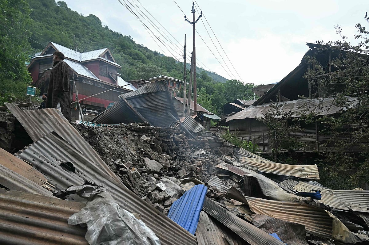 A local resident stands outside his house that was destroyed by Pakistani artillery shelling at the Lagama village in Uri, about 100kms from Srinagar, on 9 May, 2025. India and Pakistan accused each other on 8 May of carrying out waves of drone attacks, as deadly confrontations between the nuclear-armed foes drew global calls for calm.
