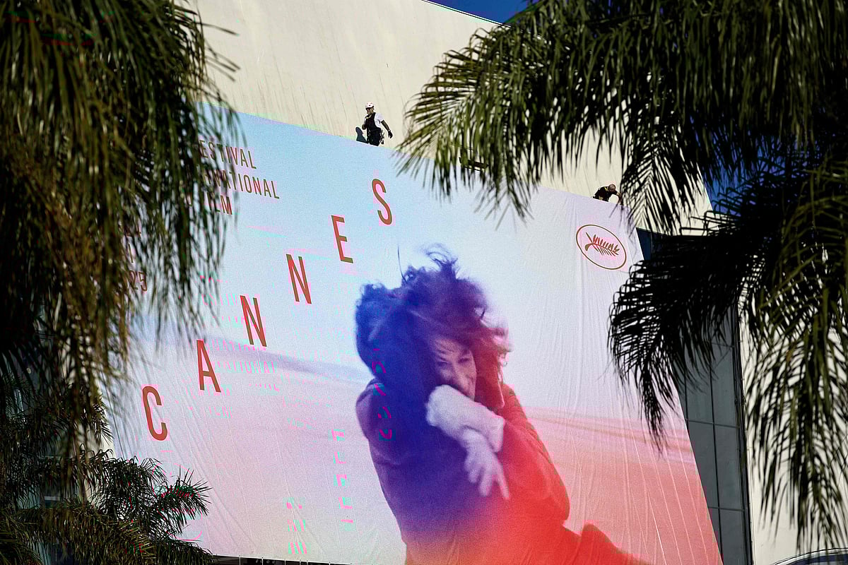 Workers hang the official poster of the 78th Cannes Film Festival on the facade of the Palais des Festivals in Cannes, south-eastern France, on 11 May, 2025. Cannes Film festival will take place from 13 May to 24 May.