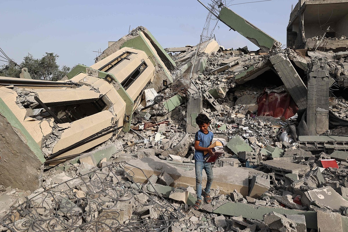 Palestinians inspect the rubble of Al-Hasanat mosque destroyed in Israeli strikes at the Nuseirat refugee camp in the central Gaza Strip on 12 May 2025
