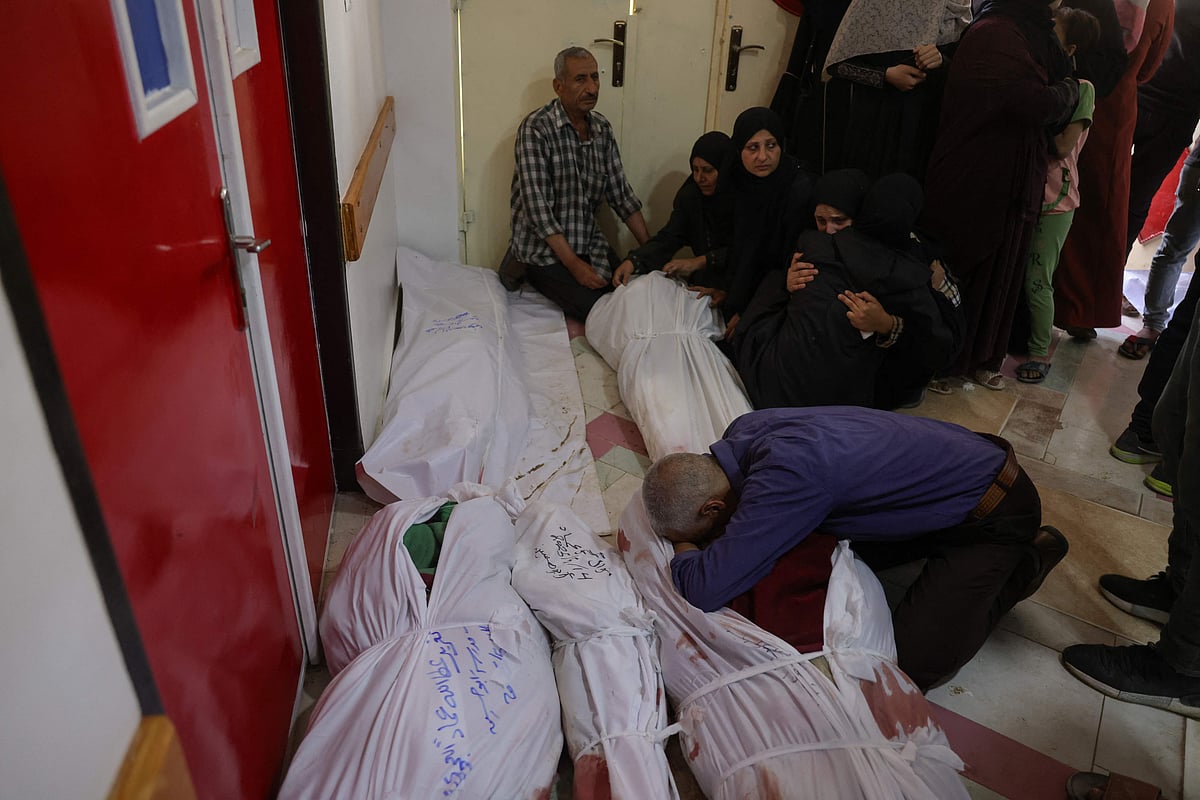 A Palestinian man reacts as she checks the bodies of people killed in Israeli strikes on Jabalia, at the Indonesian Hospital in Beit Lahia in the northern Gaza Strip on May 14, 2025