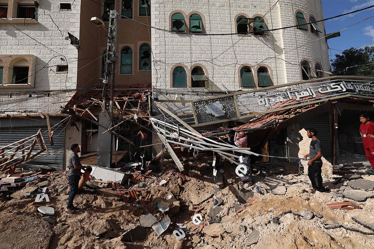 People check the aftermath of an Israeli strike in Khan Yunis in the southern Gaza Strip on 14 May 2025. Gaza's civil defence agency said at least 29 people were killed and dozens wounded in Israeli strikes on the war-battered Palestinian territory on 14 May.