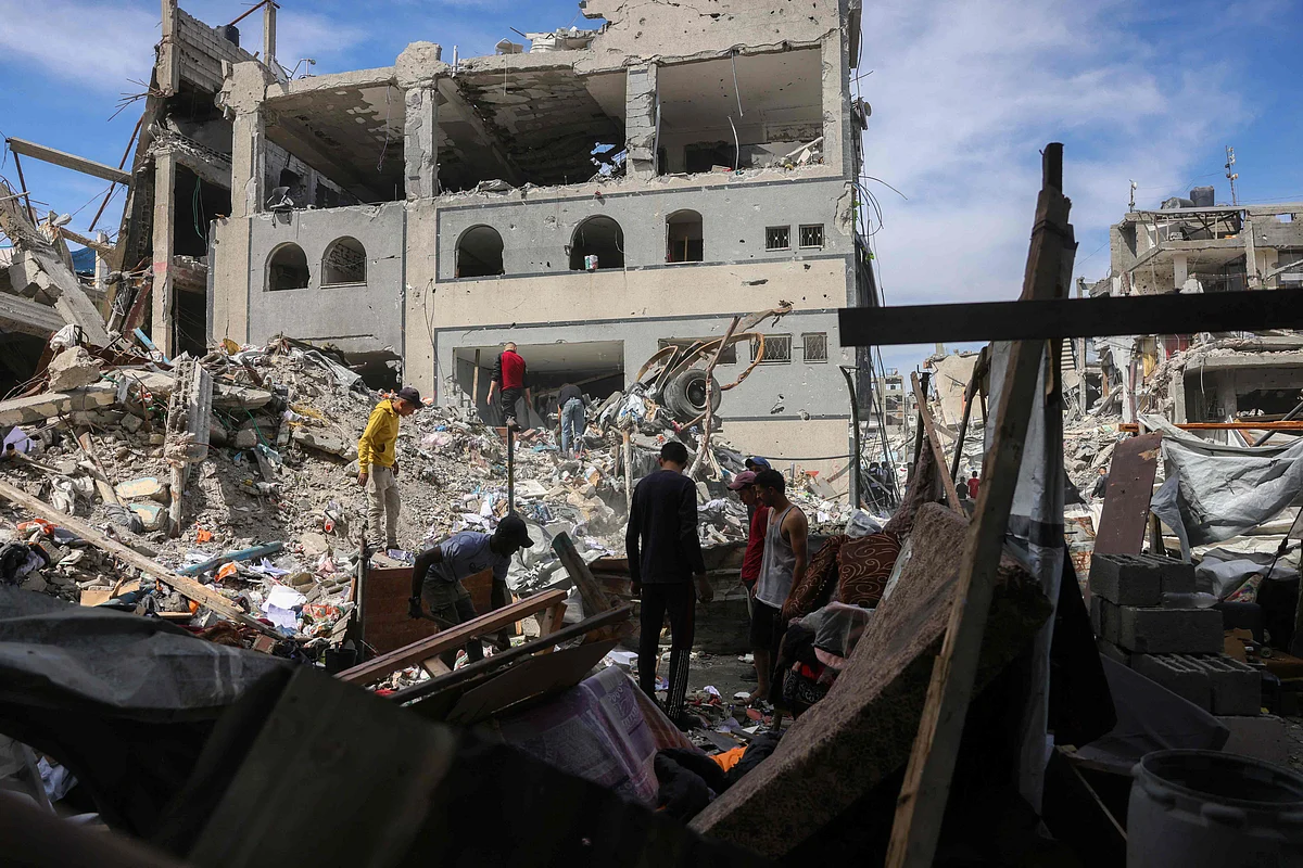 People look for salvageable items in the rubble of a building hit in an Israeli strike in Jabalia in the northern Gaza Strip on 15 May, 2025. Fighting has raged in Gaza, where civil defence officials told AFP 80 people were killed by Israeli bombardment on 14 May, including 59 in the north.