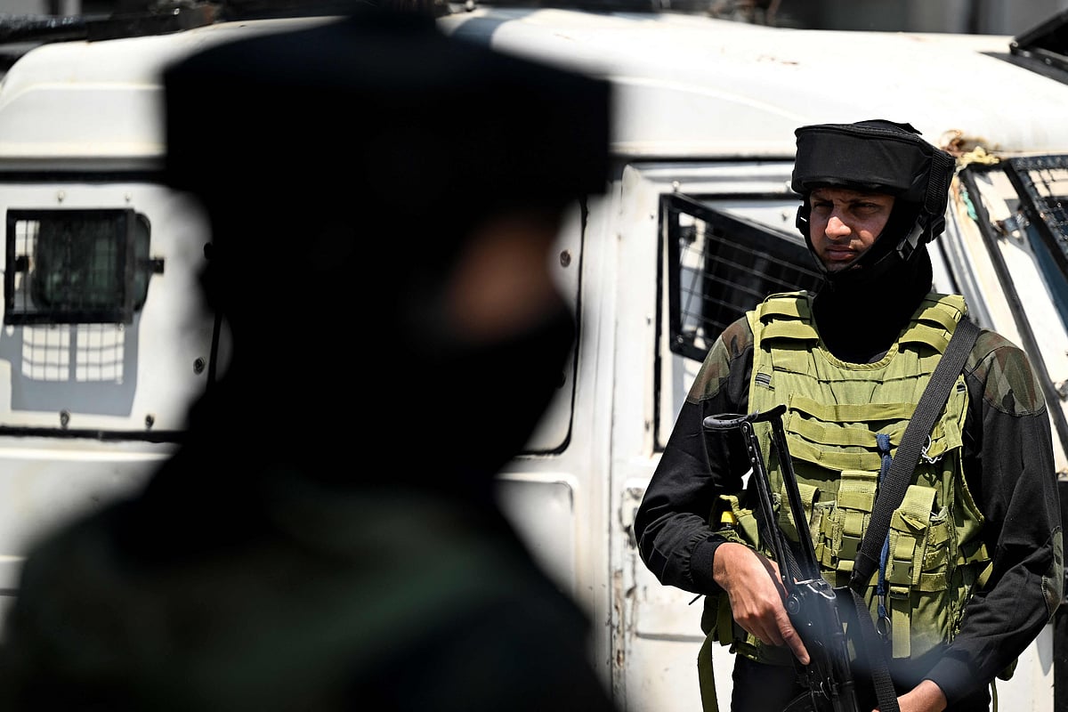 Indian paramilitary soldiers stand guard at a market place in Srinagar on 14 May 2025.