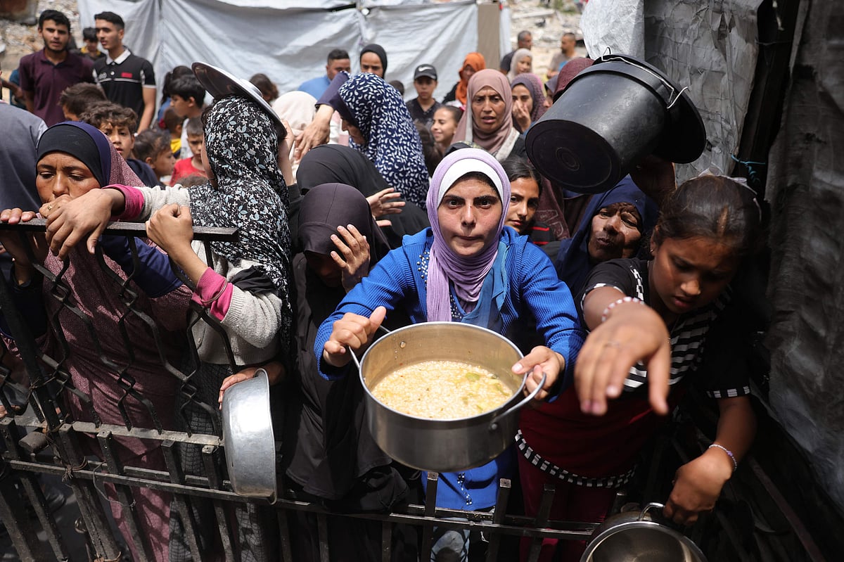 Palestinians wait for their food rations ouside a distribution centre in Beit Lahia in the northern Gaza Strip on 15 May, 2025.