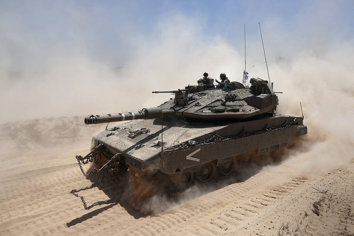 An Israeli soldier gestures atop a military vehicle at Israel's southern border with the Gaza Strip on 20 May, 2025 amid the ongoing war with the Palestinian militant movement Hamas.