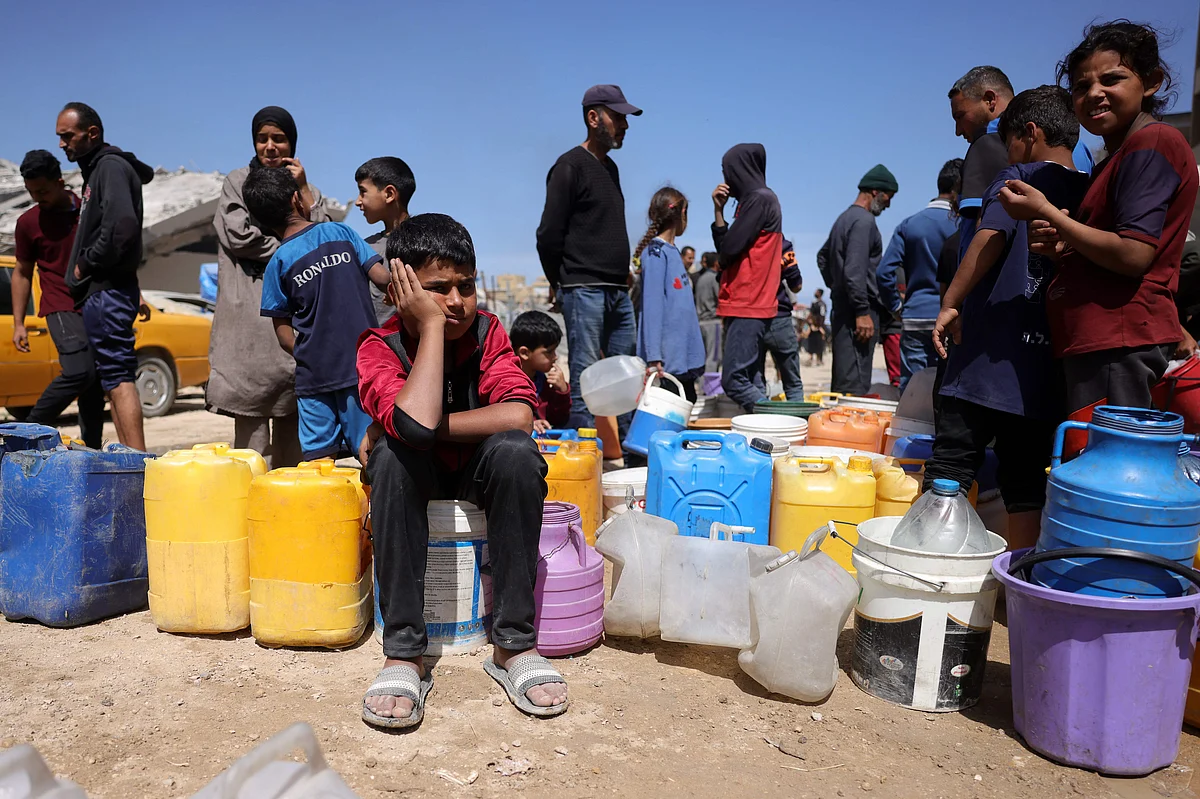 Palestinians attempt to collect water at a camp for displaced people in Gaza City, on 20 May 2025, amid the ongoing war between Israel and the Hamas