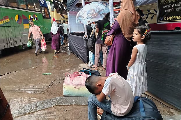 The little boy waits wearily for the bus. Thursday morning at Saidabad bus terminal in the capital.