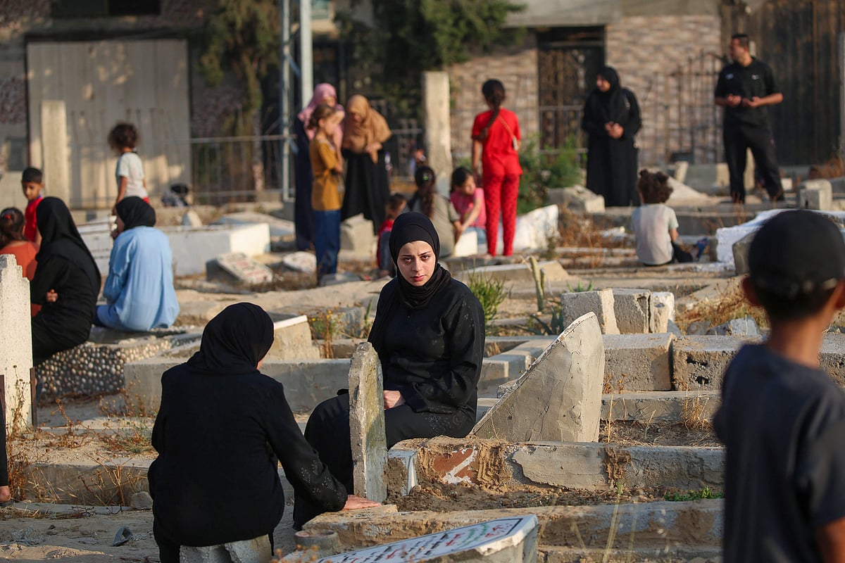 Palestinians visit the graves of their loved ones on the first day of the Muslim Eid al-Adha festival in Nuseirat, in the central Gaza Strip, on 6 June, 2025, amid the ongoing war between Israel and Hamas.