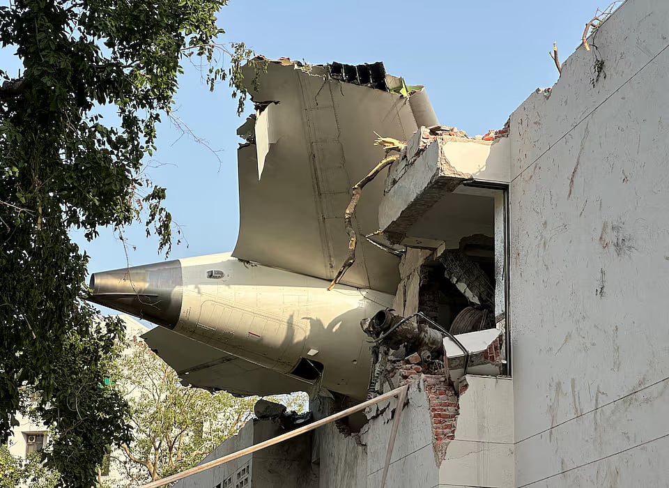 A tail of an Air India Boeing 787 Dreamliner plane that crashed is seen stuck on a building after the incident in Ahmedabad, India, 12 June, 2025.