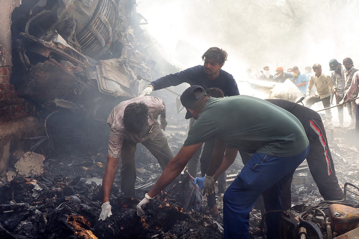 Rescue officials work at the site where Air India flight 171 crashed in a residential area near the airport in Ahmedabad on 12 June, 2025.