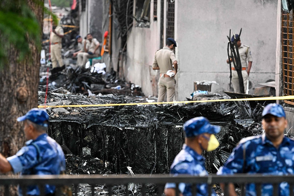 Police stand guard near wreckage at the site after Air India flight 171 crashed in a residential area near the airport in Ahmedabad, on 13 June, 2025.