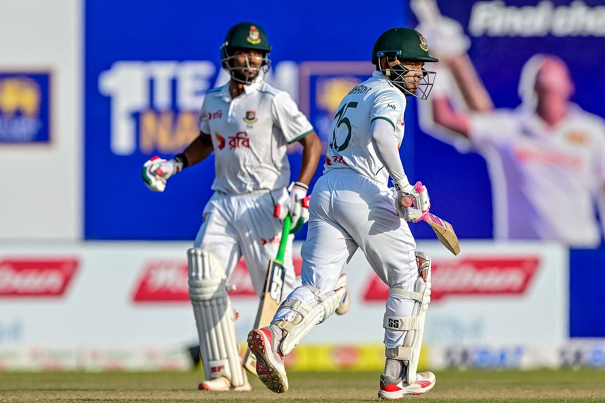 Bangladesh's Mushfiqur Rahim (R) and captain Najmul Hossain Shanto run between the wickets during the fourth day of the first Test cricket match between Sri Lanka and Bangladesh at the Galle International Cricket Stadium in Galle on 20 June, 2025.