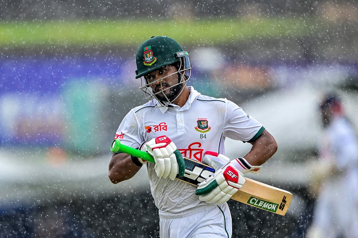 Najmul Hossain Shanto walks back to the pavilion as rain halts play during the fifth and last day of the first Test cricket match against Sri Lanka at the Galle International Cricket Stadium in Galle on 21 June, 2025.
