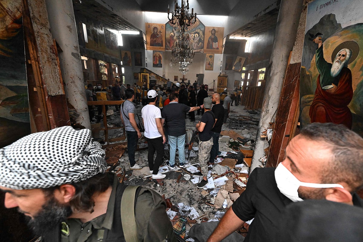 People and rescuers inspect the damage at the site of a reported suicide attack at the Saint Elias church in Damascus' Dwelaa area on 22 June 2025.