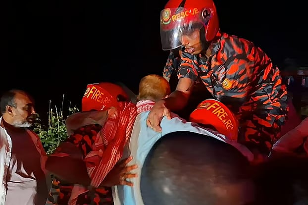 Srinagar Fire Service personnel rescue injured people from a bus that met with an accident on the expressway in Srinagar, Munshiganj