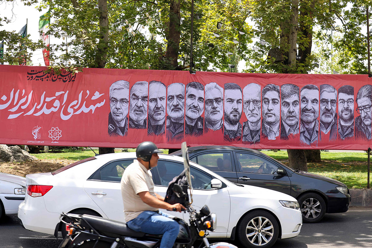 Traffic moves past a large banner depicting Iranian commanders and scientists killed in Israeli strikes during the 12-day war between Iran and Israel, at Tajrish Square in the capital Tehran on 30 June, 2025