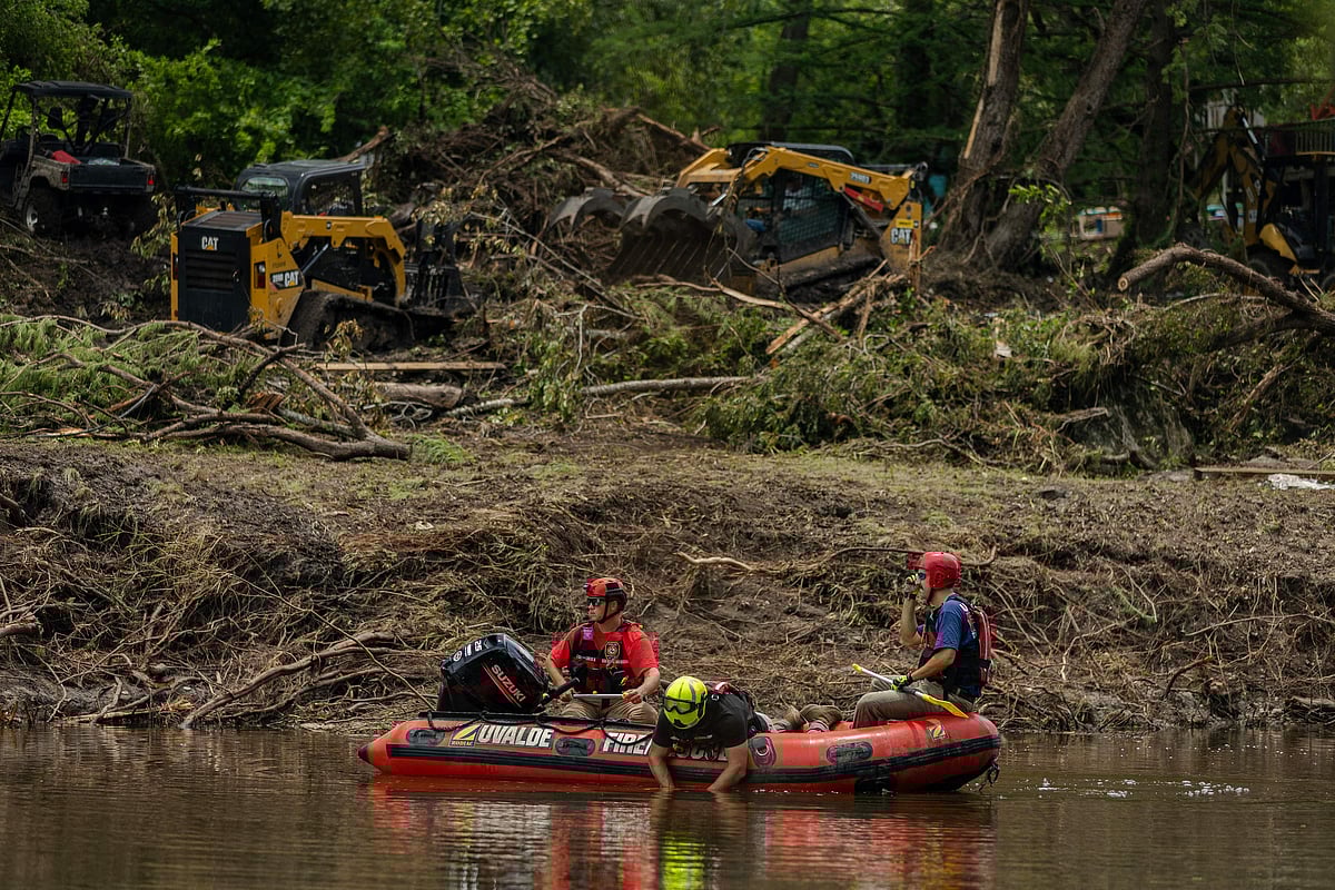 Search and rescue workers use a sonar device while paddling down the Guadalupe River in a boat looking for survivors or the remains of victims swept up in the flash flooding on 7 July, 2025 in Hunt, Texas.