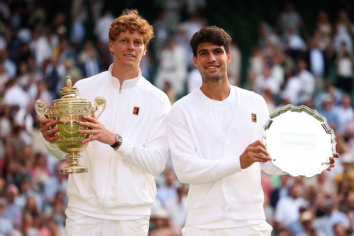 Italy's Jannik Sinner (L) holding the winner's trophy and second-placed Spain's Carlos Alcaraz pose for pictures during the price ceremony at the end of their men's singles final tennis match on the fourteenth day of the 2025 Wimbledon Championships at The All England Lawn Tennis and Croquet Club in Wimbledon, southwest London, on 13 July, 2025.