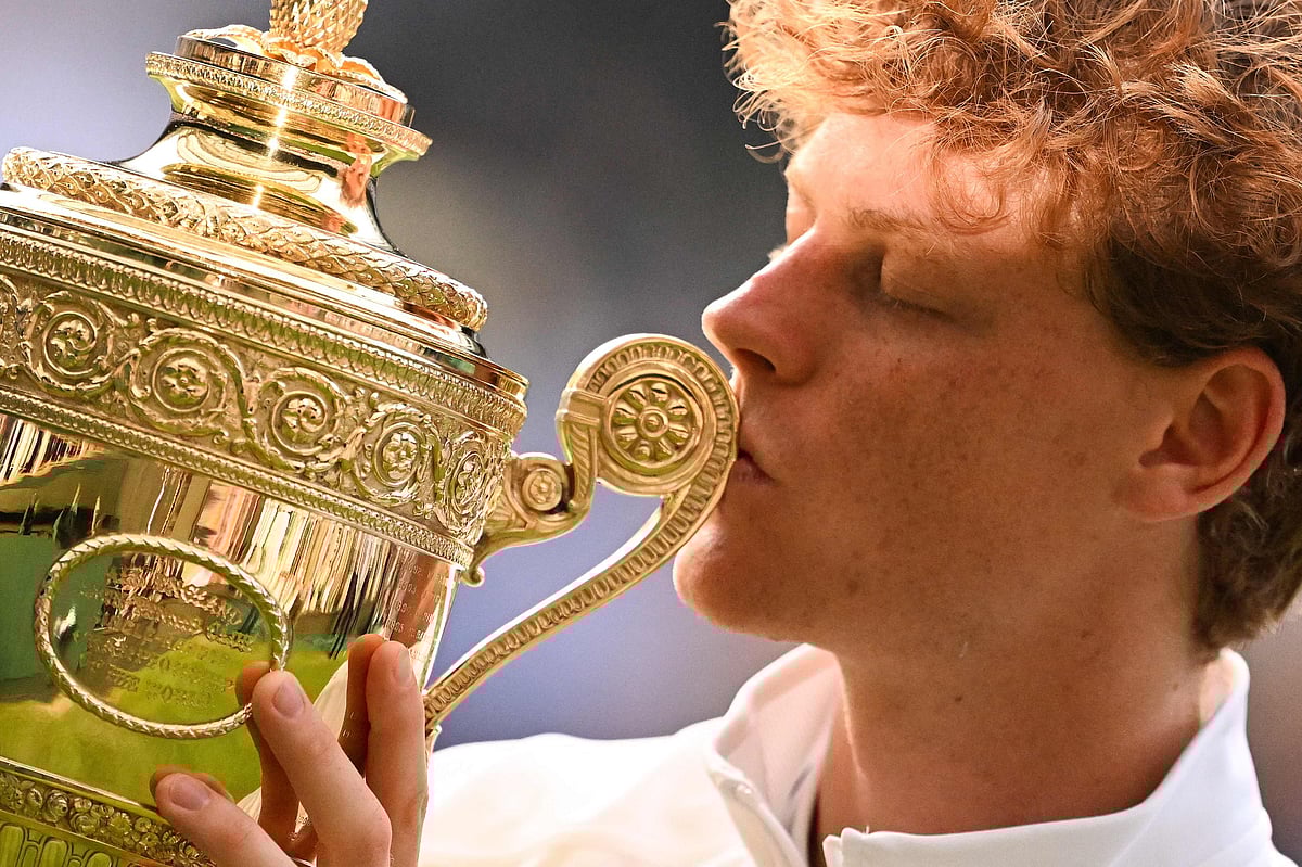 Italy's Jannik Sinner kisses the winner's trophy as he poses for pictures following his victory against Spain's Carlos Alcaraz at the end of their men's singles final tennis match on the fourteenth day of the 2025 Wimbledon Championships at The All England Lawn Tennis and Croquet Club in Wimbledon, southwest London, on 13  July, 2025.