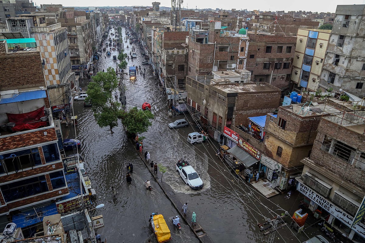 Commuters make their way through a flooded street during heavy monsoon rains in Hyderabad, in Sindh province, Pakistan on 14 July 2025.